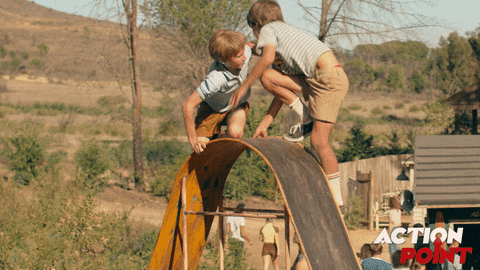 Child pushes another child off a slide so that he can go down first.