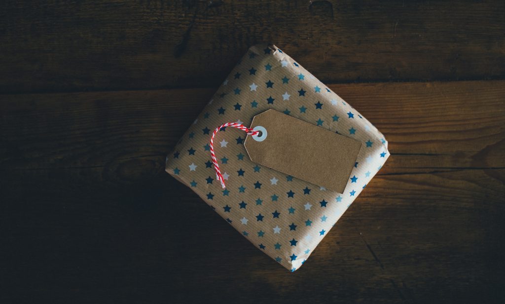 A beautifully wrapped package sits on a wooden table