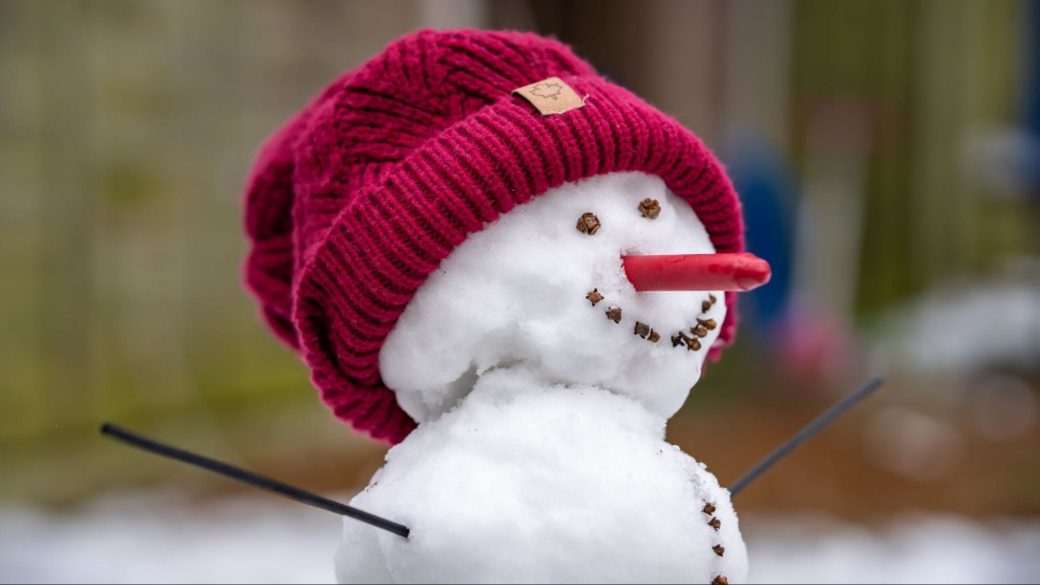 A snowman wearing a red cap