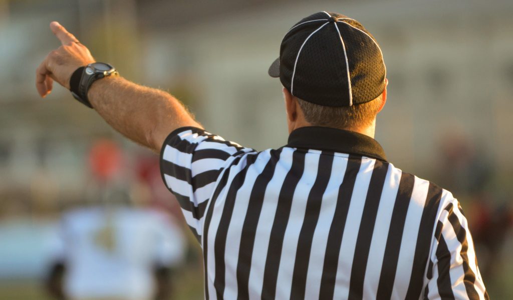 A shot of a ref from behind, pointing