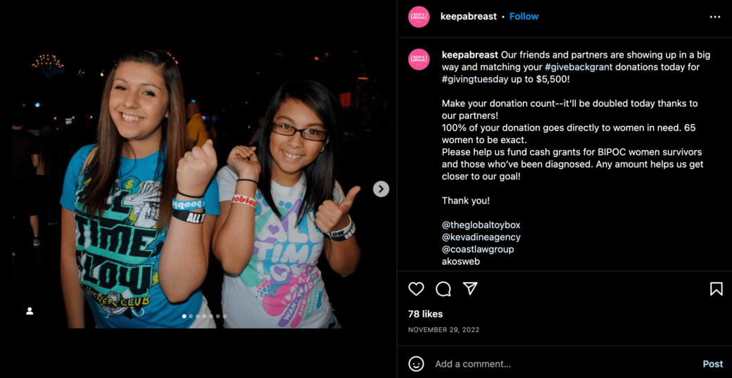 Two young women in a club hold up their wrists to show off bracelets that says "boobies"